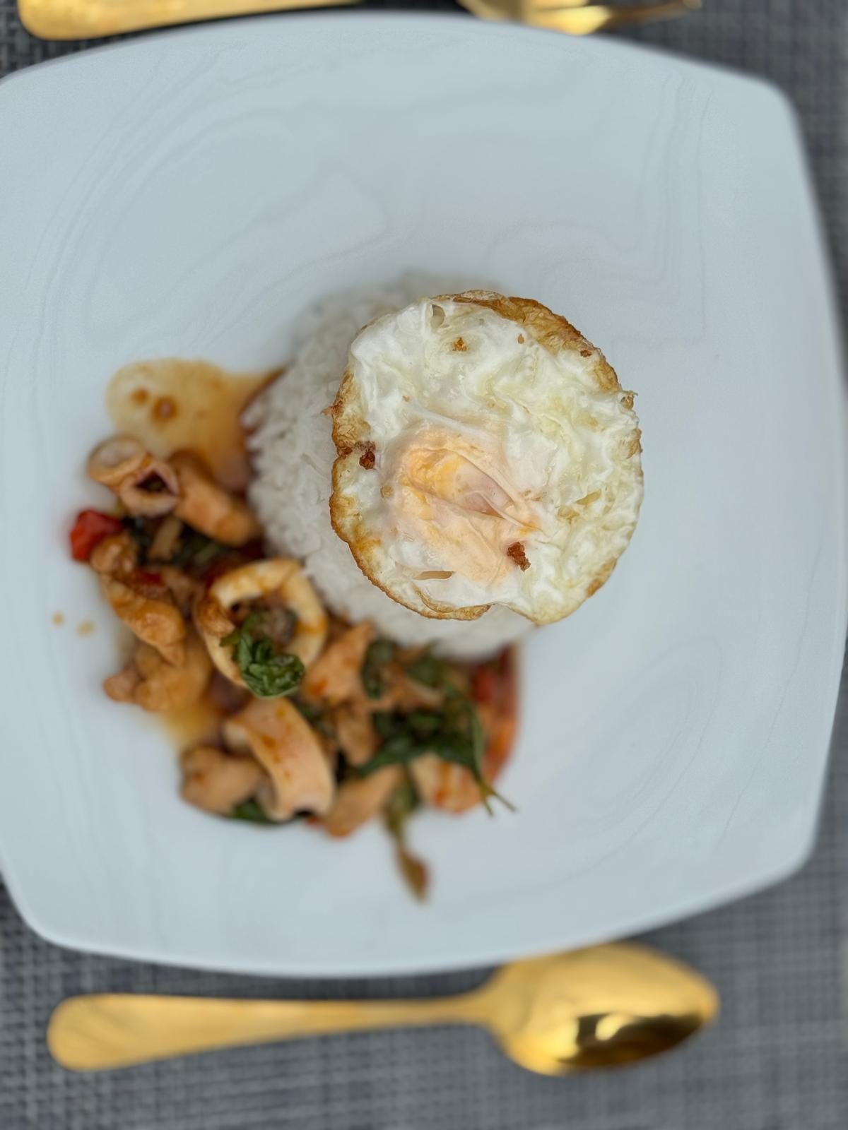 Stir-fried squid with basil, rice and a fried egg